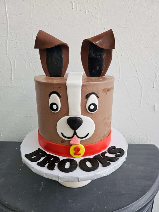 Brown fondant dog face 2nd birthday cake shaped as cartoon dog with floppy ears, red collar, cartoon eyes and nose